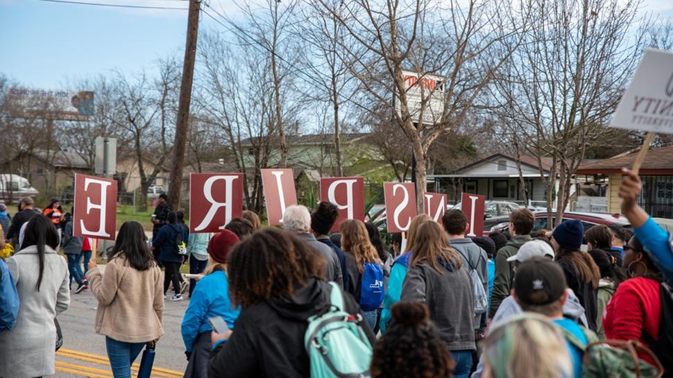 在马丁·路德·金游行中，学生们举着写有“鼓舞”的标语. 