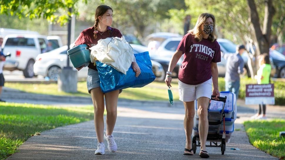 Two students on move in day carrying their belongings